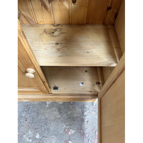 37 - A pine bookcase with three upper shelves and two lower cupboard doors