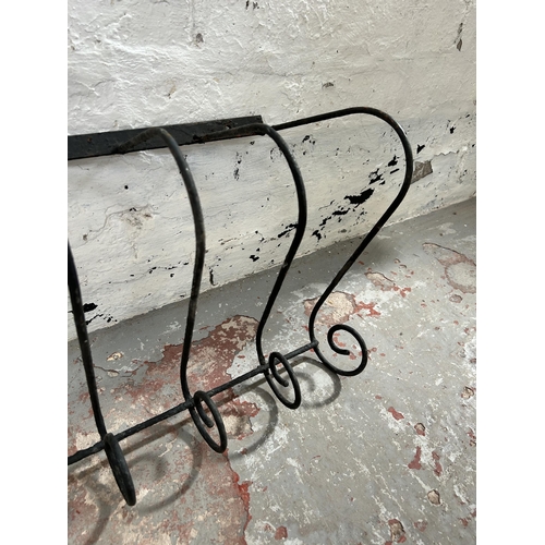 57 - A wrought iron wall hanging rack - approx. 155cm long