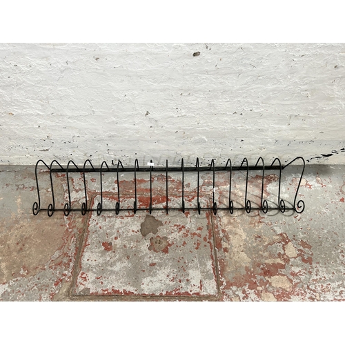 57 - A wrought iron wall hanging rack - approx. 155cm long