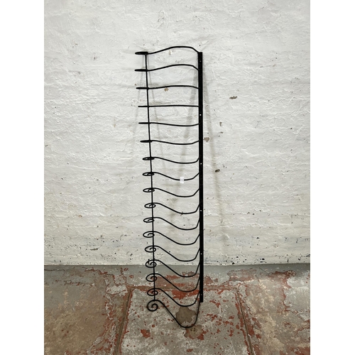 57 - A wrought iron wall hanging rack - approx. 155cm long