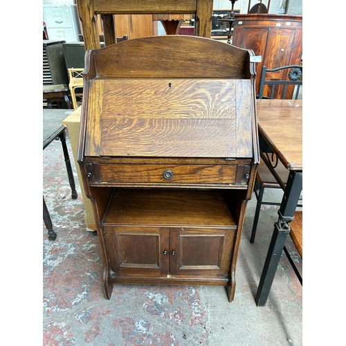 71 - An early/mid 20th century oak bureau with fall front and two cupboard doors