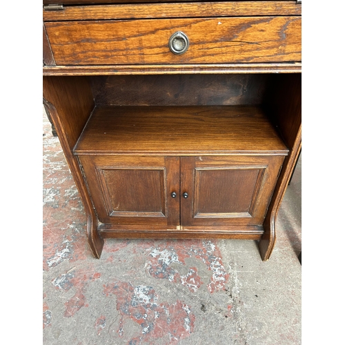 71 - An early/mid 20th century oak bureau with fall front and two cupboard doors