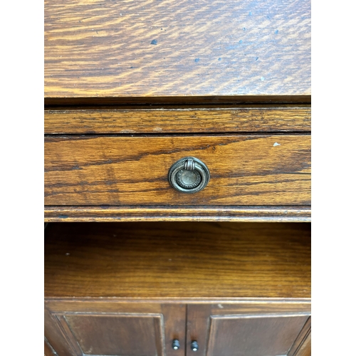 71 - An early/mid 20th century oak bureau with fall front and two cupboard doors