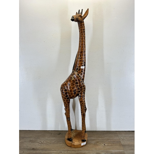 670 - A carved hardwood giraffe figurine - approx. 91cm high