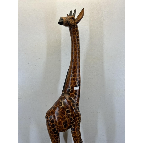 670 - A carved hardwood giraffe figurine - approx. 91cm high