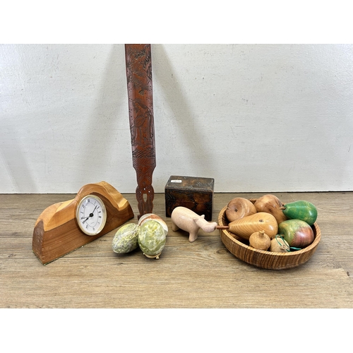 675 - A collection of carved items to include semi precious stone eggs, wooden quartz mantel clock etc.