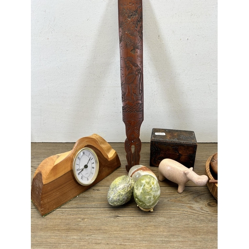 675 - A collection of carved items to include semi precious stone eggs, wooden quartz mantel clock etc.