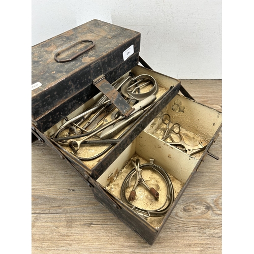 678 - An early/mid 20th century black metal cantilever three section medical box with contents