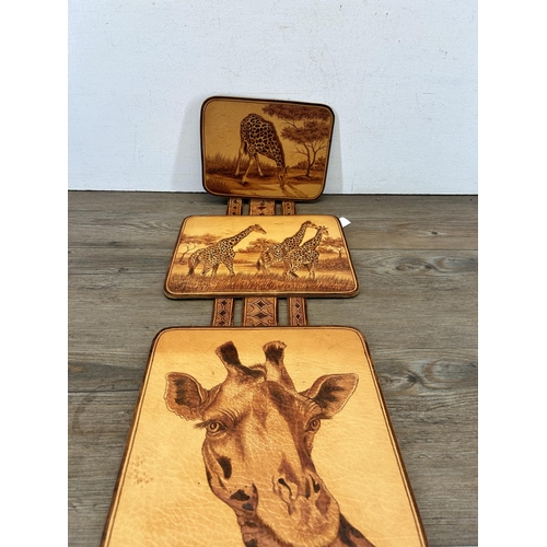 679 - A hand tooled leather tryptic giraffe wall hanging, signed G. Jacobs 2000 - approx. 80cm high