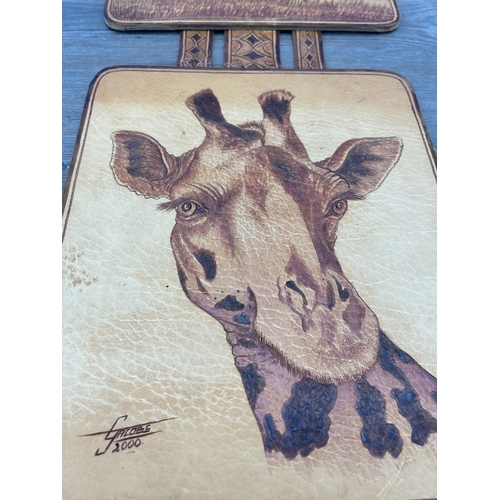 679 - A hand tooled leather tryptic giraffe wall hanging, signed G. Jacobs 2000 - approx. 80cm high