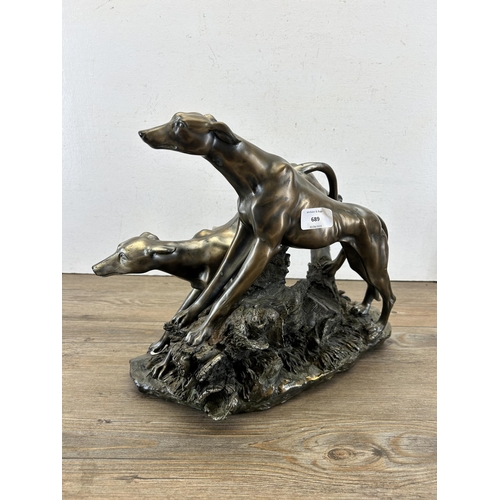 689 - A modern bronze effect figurine of two sighthounds - approx. 31cm high x 38cm long