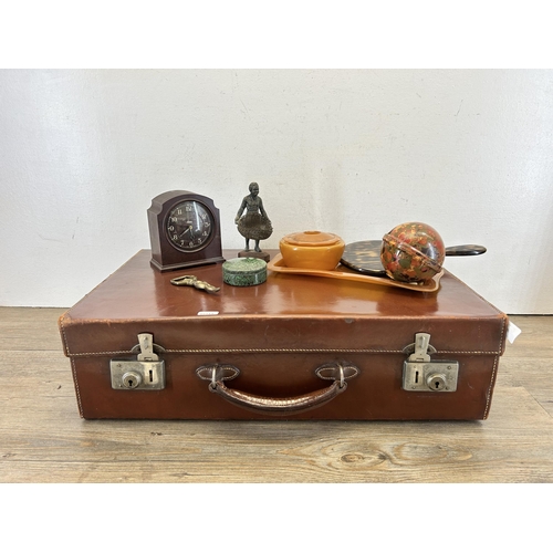 698 - A vintage brown leather suitcase with contents