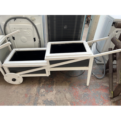 723 - Two grey and white painted wooden two step wheelbarrow planters - largest approx. 64.5cm high x 38cm... 