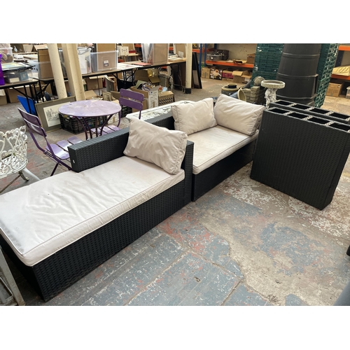 772 - A four piece rattan effect garden patio set comprising two sofas and two table bases