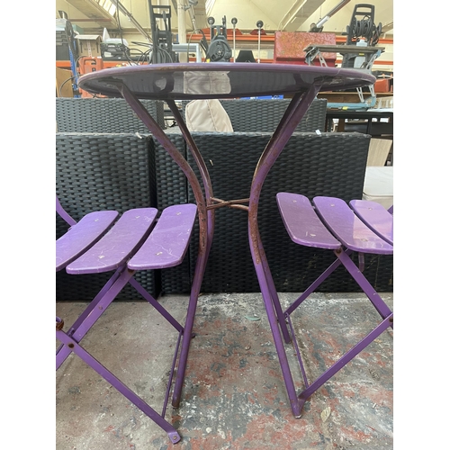 790 - A three piece purple metal bistro set comprising two folding chairs and table