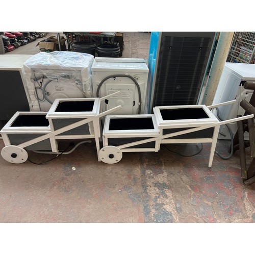 723 - Two grey and white painted wooden two step wheelbarrow planters - largest approx. 64.5cm high x 38cm... 