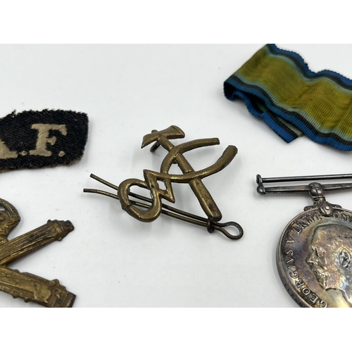 1402 - Five military items, two WWI medals presented to 117968 Pte. L. J. Warren M. G. C, two cap badges an... 