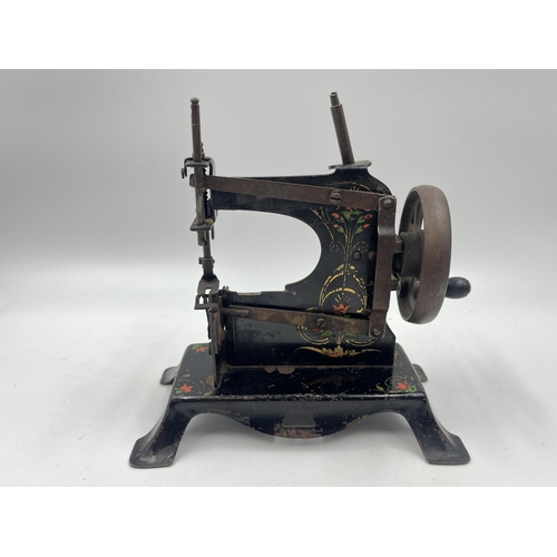 1465 - An early 20th century hand painted black metal hand crank toy sewing machine - approx. 17cm high