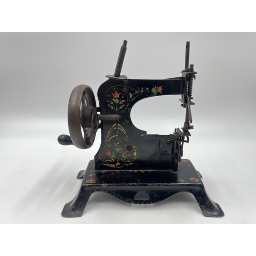 1465 - An early 20th century hand painted black metal hand crank toy sewing machine - approx. 17cm high