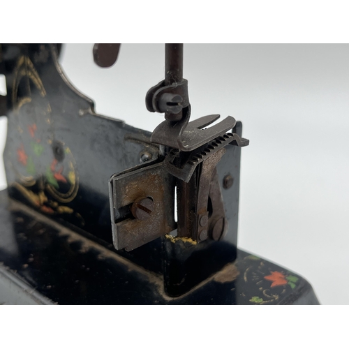 1465 - An early 20th century hand painted black metal hand crank toy sewing machine - approx. 17cm high