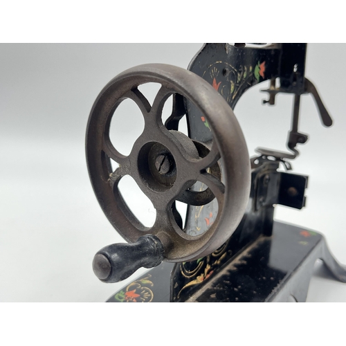 1465 - An early 20th century hand painted black metal hand crank toy sewing machine - approx. 17cm high