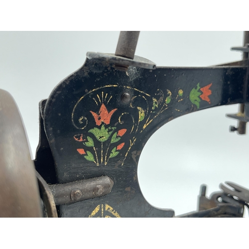 1465 - An early 20th century hand painted black metal hand crank toy sewing machine - approx. 17cm high