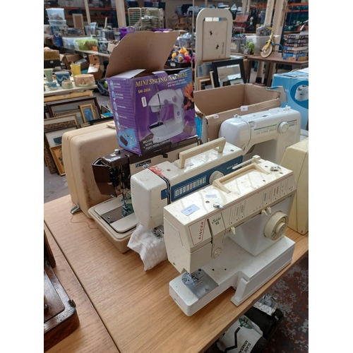 927 - Four electric sewing machines, one cased Janome New Home 921, one boxed SM-202A Mini with foot pedal... 