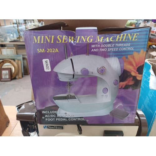 927 - Four electric sewing machines, one cased Janome New Home 921, one boxed SM-202A Mini with foot pedal... 