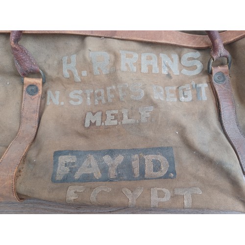 702C - A mid 20th century canvas and leather military bag marked K.R. RANS N.STAFFS REG'T M.E.L.F. FAYID EG... 