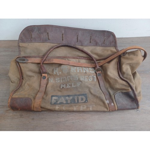 702C - A mid 20th century canvas and leather military bag marked K.R. RANS N.STAFFS REG'T M.E.L.F. FAYID EG... 