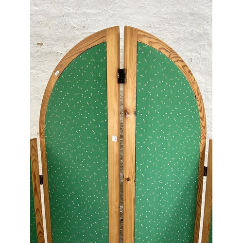 125 - A late 20th century pine and green fabric four section folding dressing screen