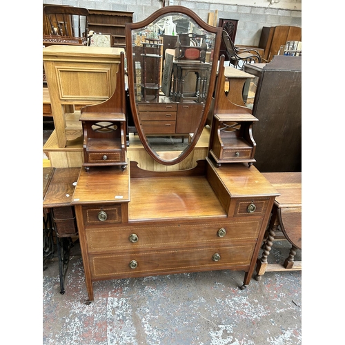 126 - An Edwardian inlaid mahogany dressing table with six drawers, shield shaped mirror and tapering supp... 