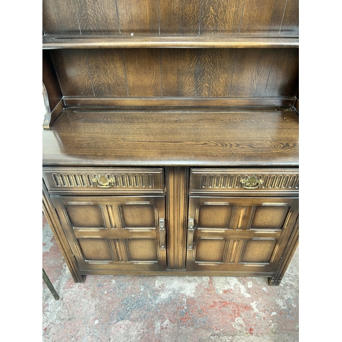 152 - An oak Welsh dresser with two drawers, two cupboard doors and upper plate rack