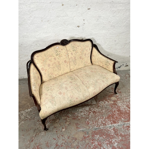 185 - An Edwardian carved mahogany and floral upholstered two seater parlour sofa with cabriole supports a... 