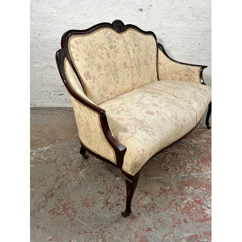 185 - An Edwardian carved mahogany and floral upholstered two seater parlour sofa with cabriole supports a... 