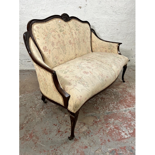 185 - An Edwardian carved mahogany and floral upholstered two seater parlour sofa with cabriole supports a... 