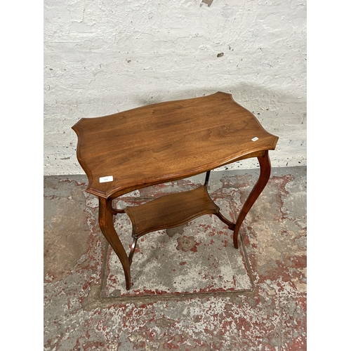 223 - An Edwardian walnut serpentine two tier side table