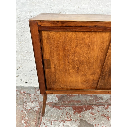 225 - A mid 20th century plywood two door cabinet with splayed supports - approx. 76cm high x 77cm wide x ... 