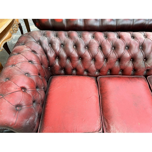 239 - An oxblood leather Chesterfield three seater sofa