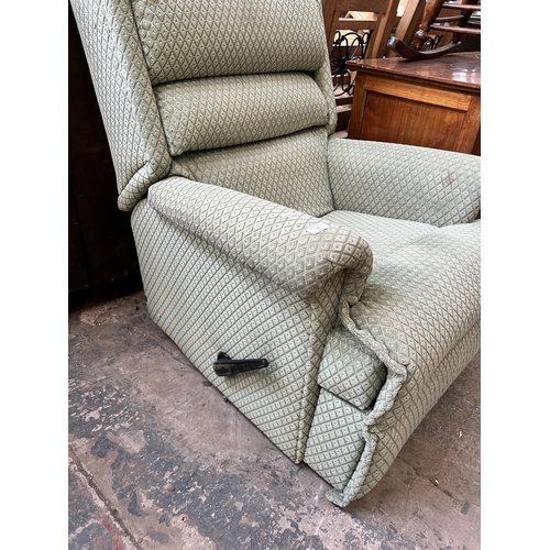 24 - A green fabric reclining armchair