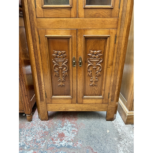 61 - An Edwardian style carved oak free standing corner cabinet