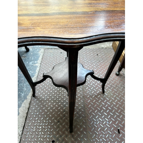64 - An Edwardian mahogany serpentine two tier occasional table