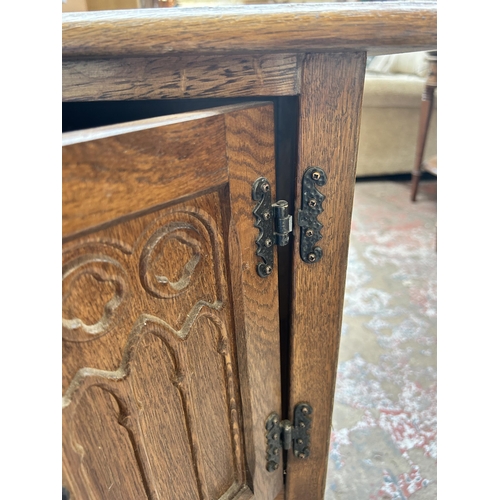 79 - A 17th century style carved oak two door side cabinet