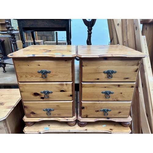 95 - A pair of pine bedside chests of three drawers