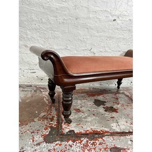 105 - A Regency mahogany and pink fabric upholstered window seat with turned supports and castors