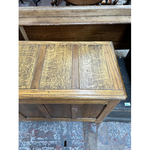 128 - An early/mid 20th century oak four panel blanket box with fitted interior