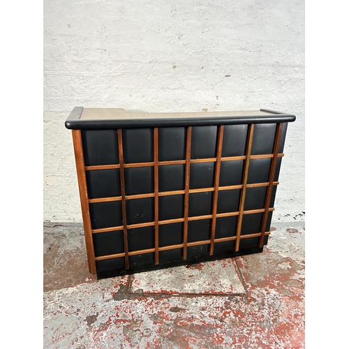 134 - A mid 20th century teak and black vinyl drinks cabinet/bar with formica top and contents
