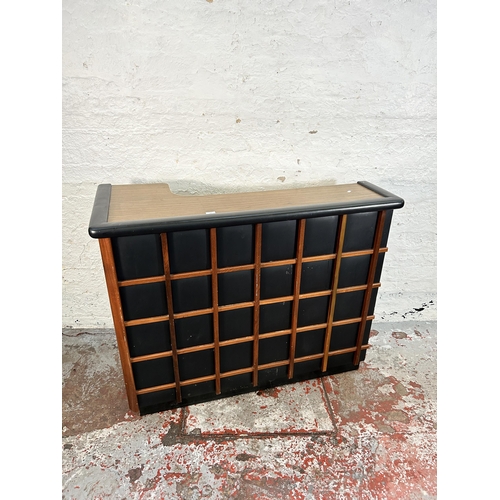 134 - A mid 20th century teak and black vinyl drinks cabinet/bar with formica top and contents