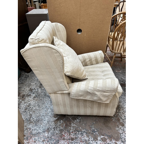 139 - A modern fabric upholstered wingback armchair on castors
