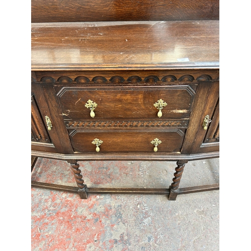 157 - A Waring & Gillow Ltd. carved oak sideboard with two drawers, two linenfold doors and barley twist s... 